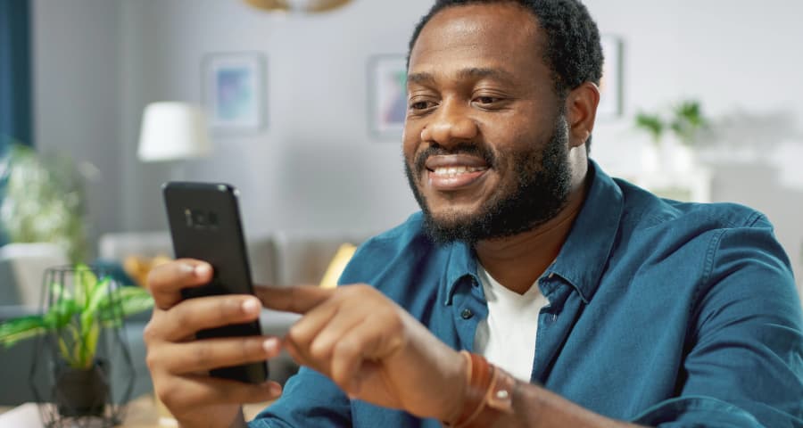 Man sitting down interacting with an app on his smartphone